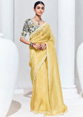 Light yellow saree featuring sequence work and embroidery for festive occasions.