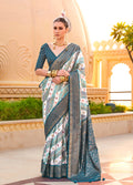 Vibrant teal silk saree featuring intricate metallic foil print details