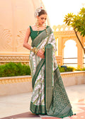 Elegant green silk saree with gold-tone ethnic foil print detailing.