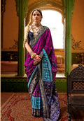 Woman wearing a vibrant magenta silk saree with traditional Patola print