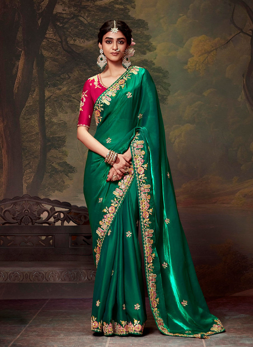 Green organza saree with intricate thread work embroidery draped elegantly.