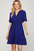 Model wearing a feminine ruffled surplice mini dress with flutter sleeves.