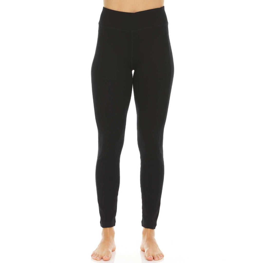 A woman wearing fitted, high-rise solid black Woolverino midweight leggings for an athletic, minimalist look.