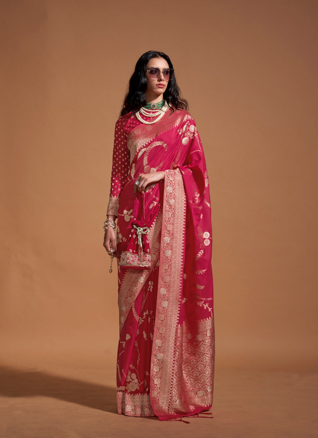 Vibrant rani pink silk designer saree with traditional weaving details.