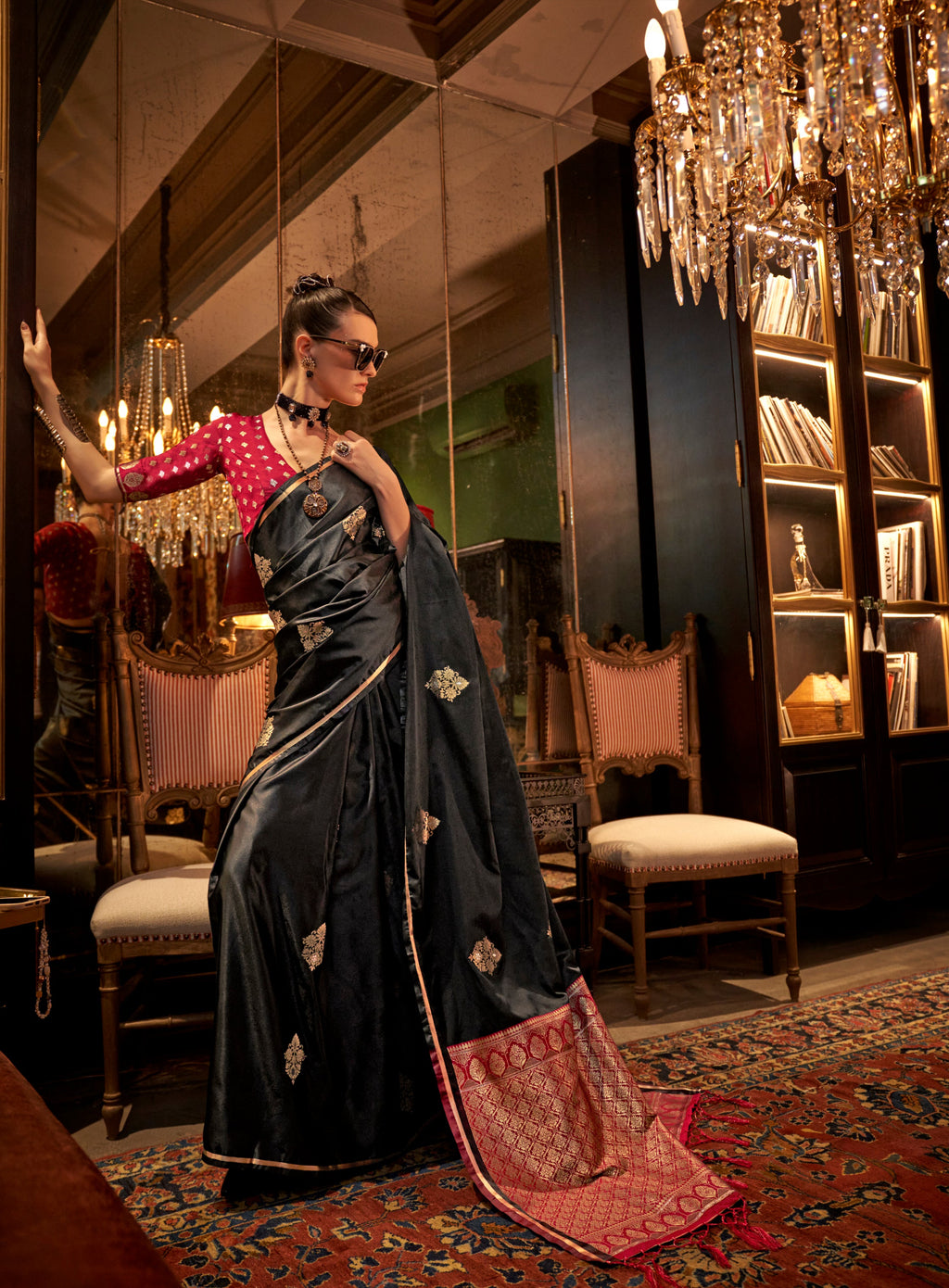 Model wearing a black satin saree with intricate gold weaving work