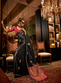 Model wearing a black satin saree with intricate gold weaving work