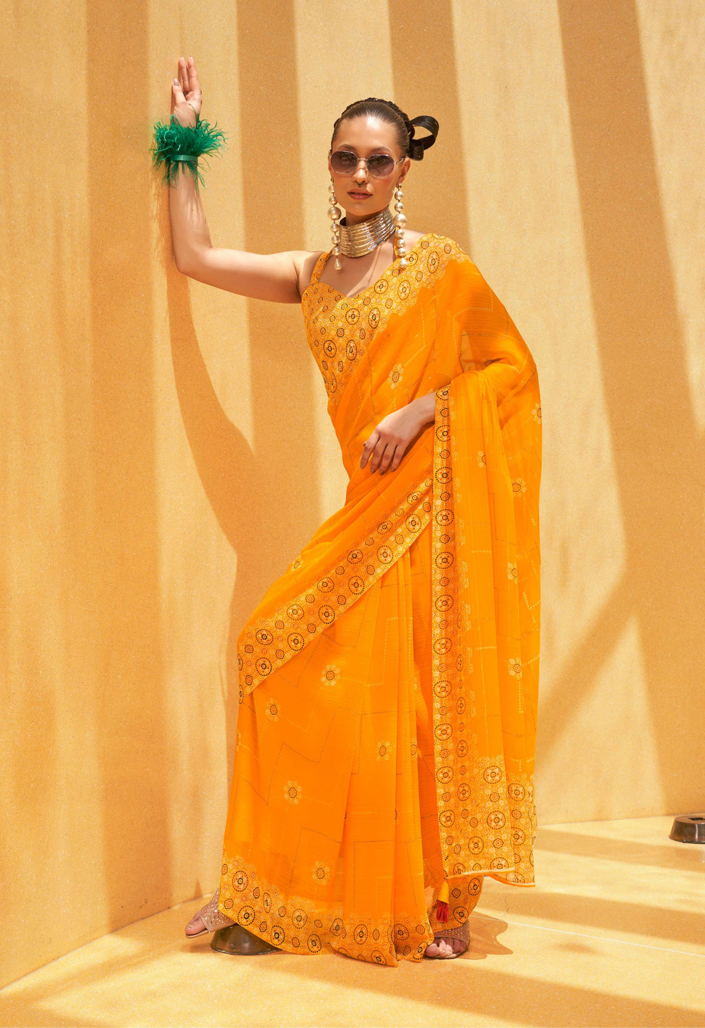 Woman wearing a bright yellow georgette saree with vibrant ethnic prints