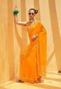 Woman wearing a bright yellow georgette saree with vibrant ethnic prints