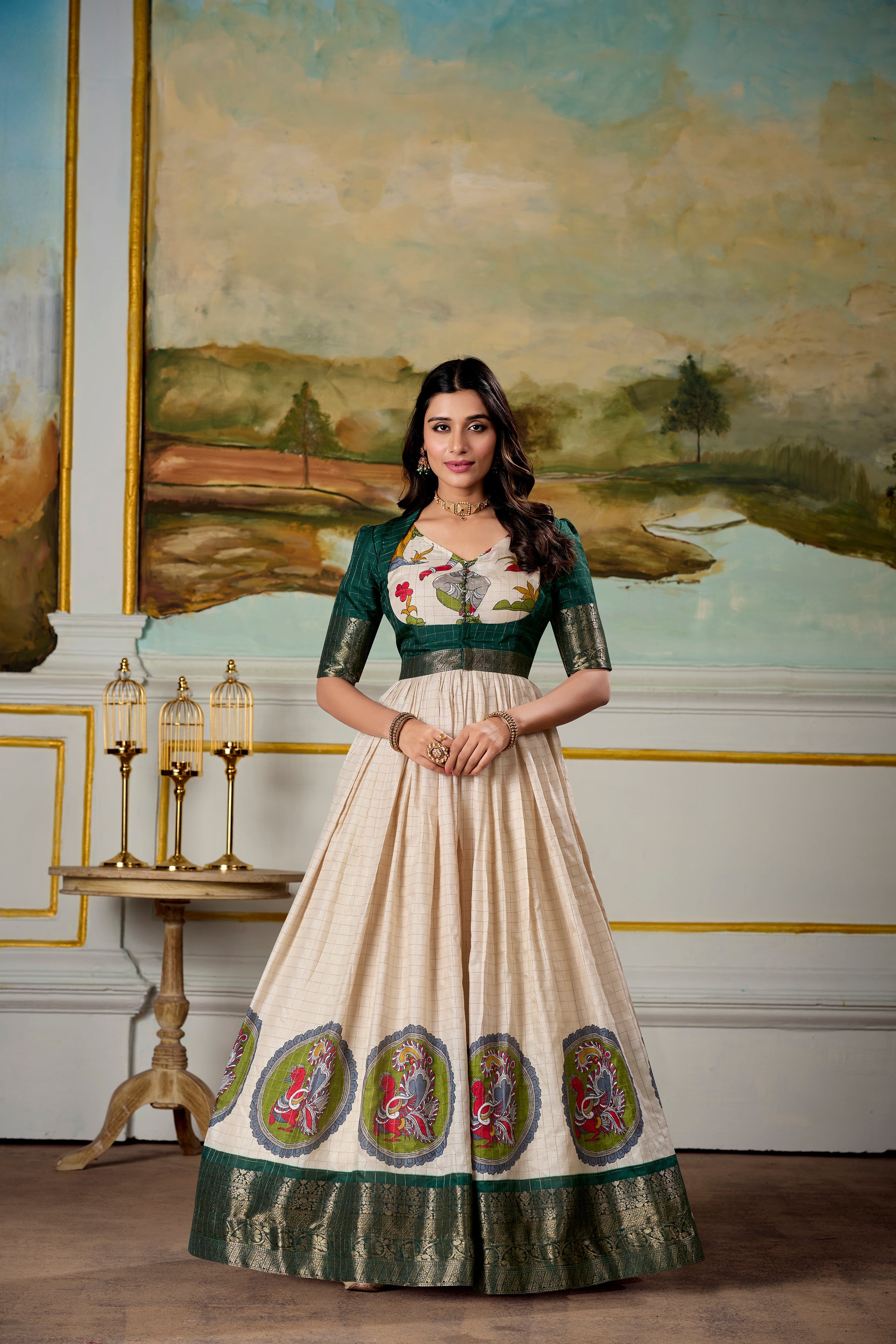 Woman wearing a cream and green Dola silk Kalamkari gown with zari border and matching koti