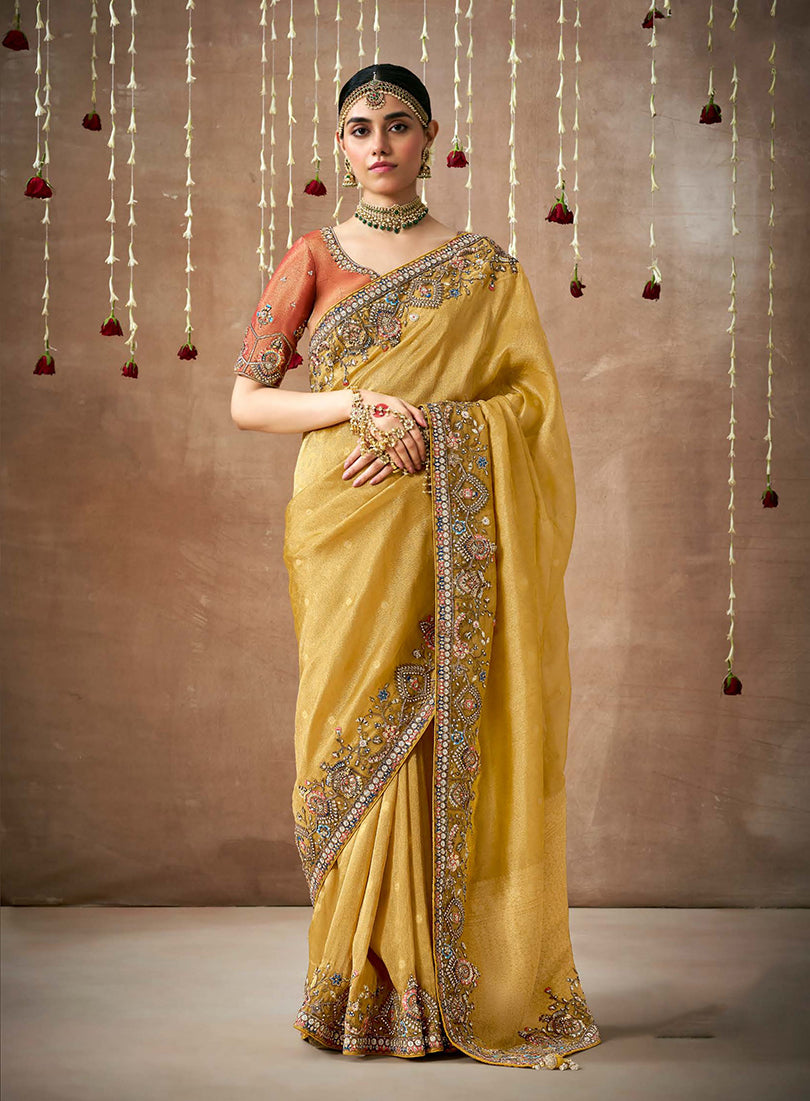 Mustard organza saree featuring detailed embroidery for a Bollywood look.