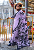 A graceful woman wearing a lavender printed satin saree with a classic drape and elegant finish.