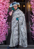 A classic white and black printed satin saree with a smooth finish.