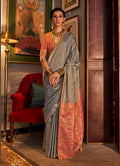 A traditional grey Tussar silk saree with elegant woven detailing.