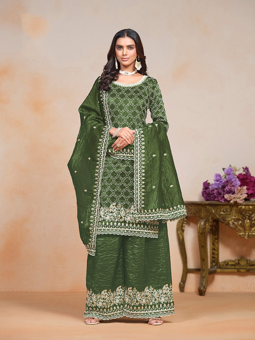 Woman wearing a dark-green embroidered art silk salwar suit with palazzo pants