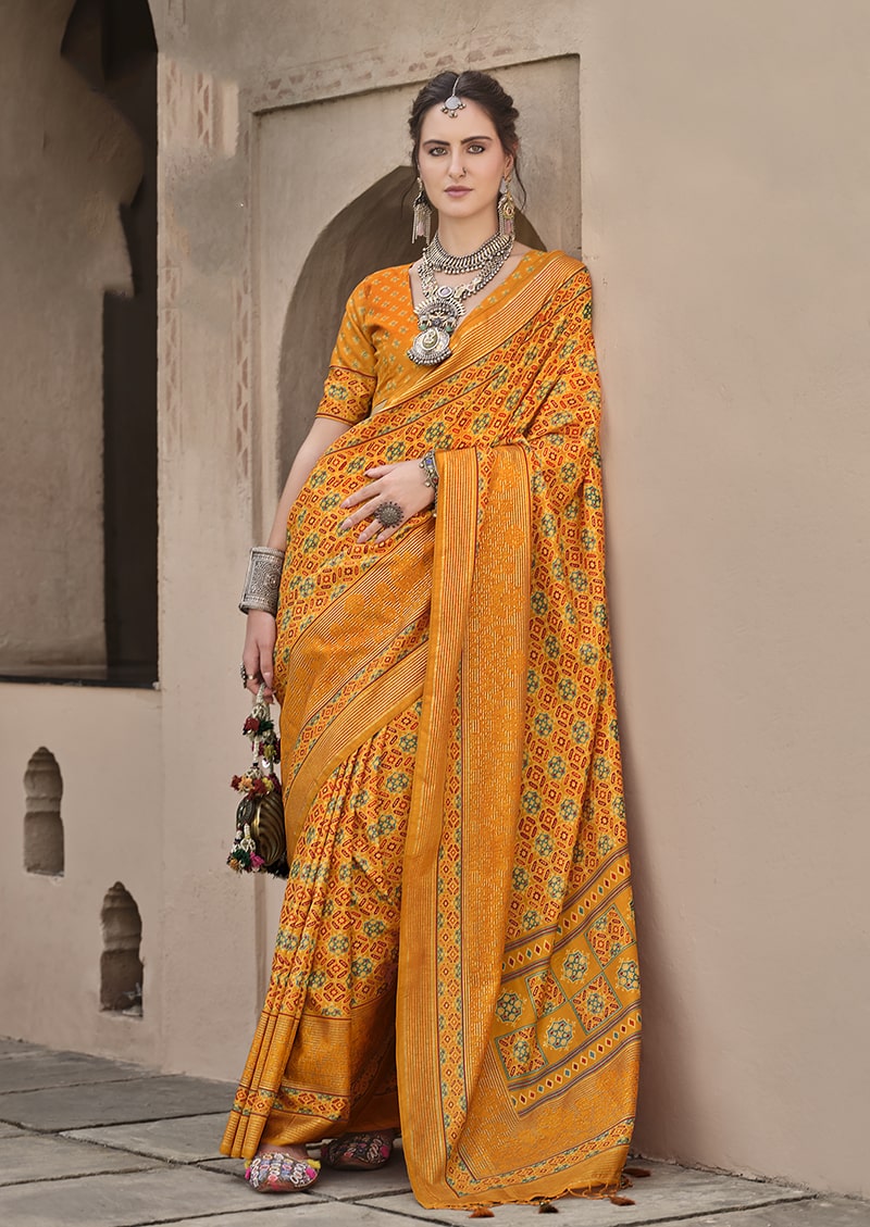 Amber silk traditional saree with geometric Patola print patterns in yellow, green, and red.