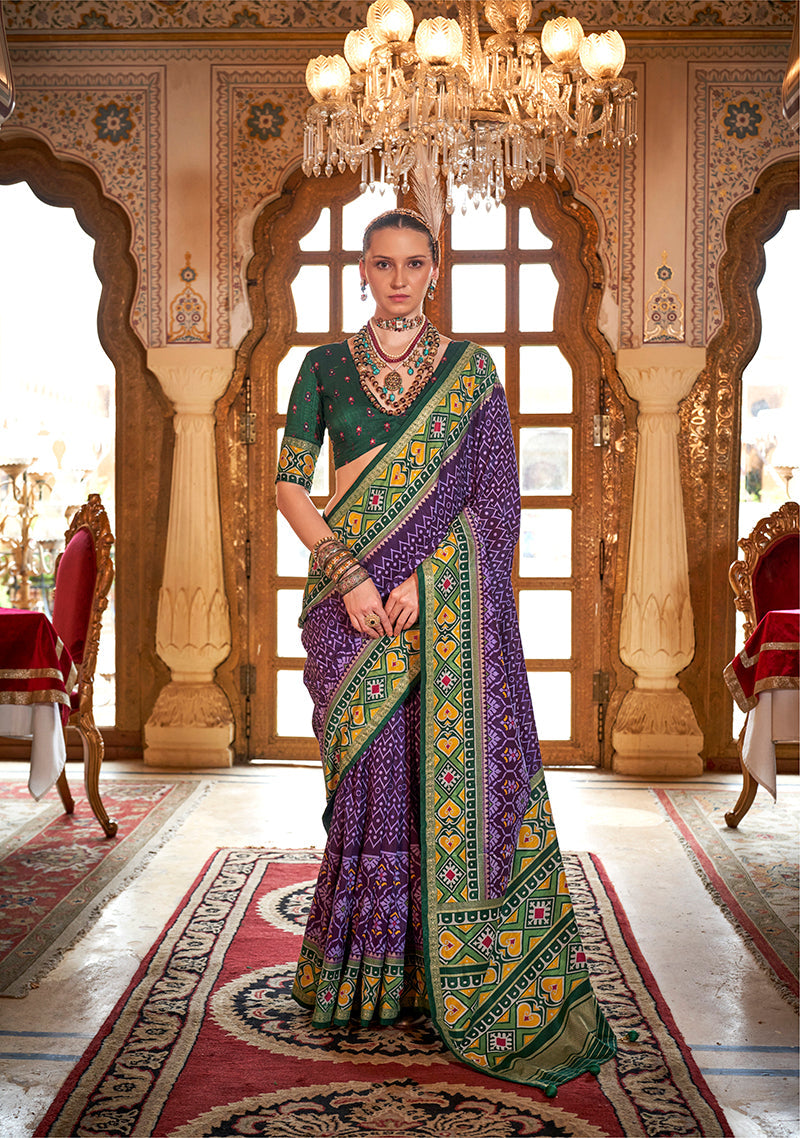 A vibrant purple silk saree with traditional Patola print patterns for festival wear.