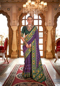 A vibrant purple silk saree with traditional Patola print patterns for festival wear.