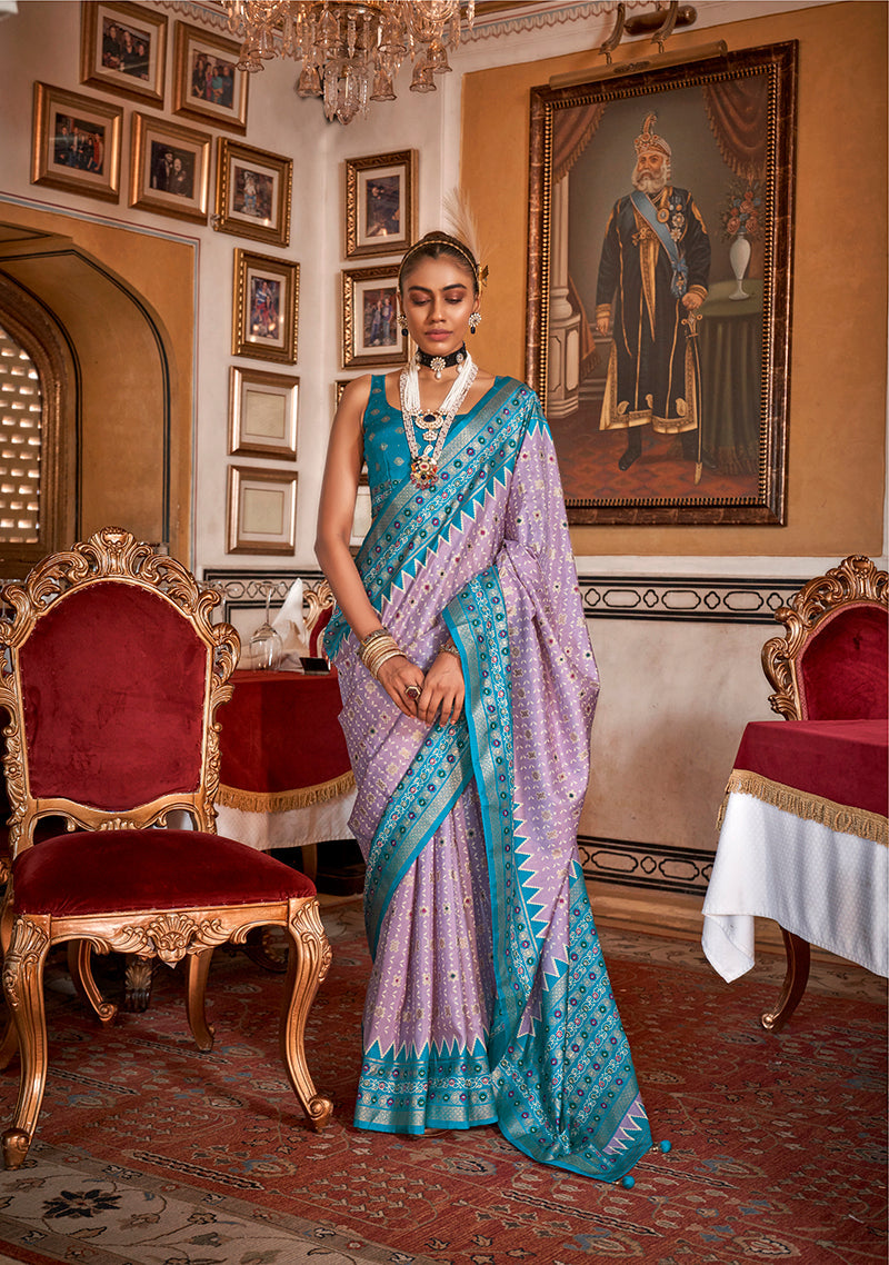 Lavender silk saree with an aqua blue border and decorative floral print patterns.