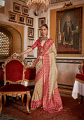 Cream silk saree featuring a traditional red printed border.