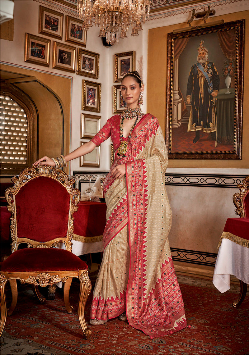 Cream silk saree featuring a traditional red printed border.