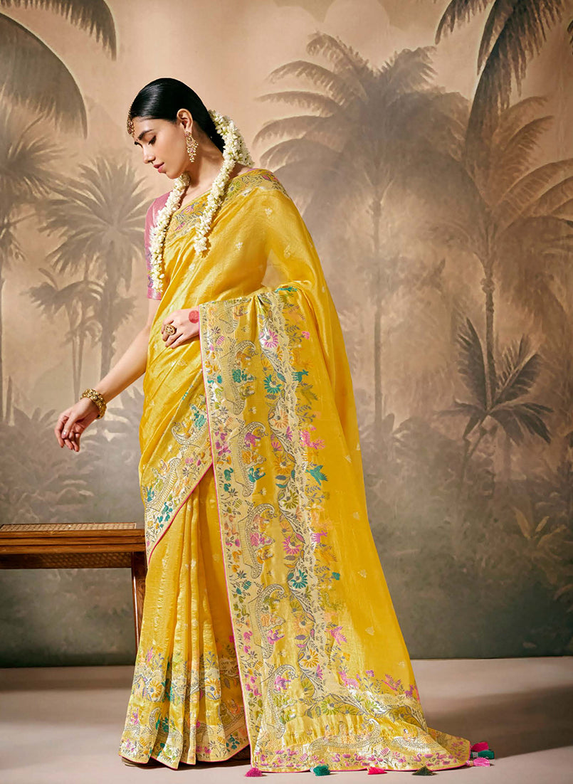 Mustard silk saree with floral pattern and gold zari work paired with unstitched blouse