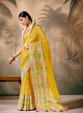 Mustard silk saree with floral pattern and gold zari work paired with unstitched blouse