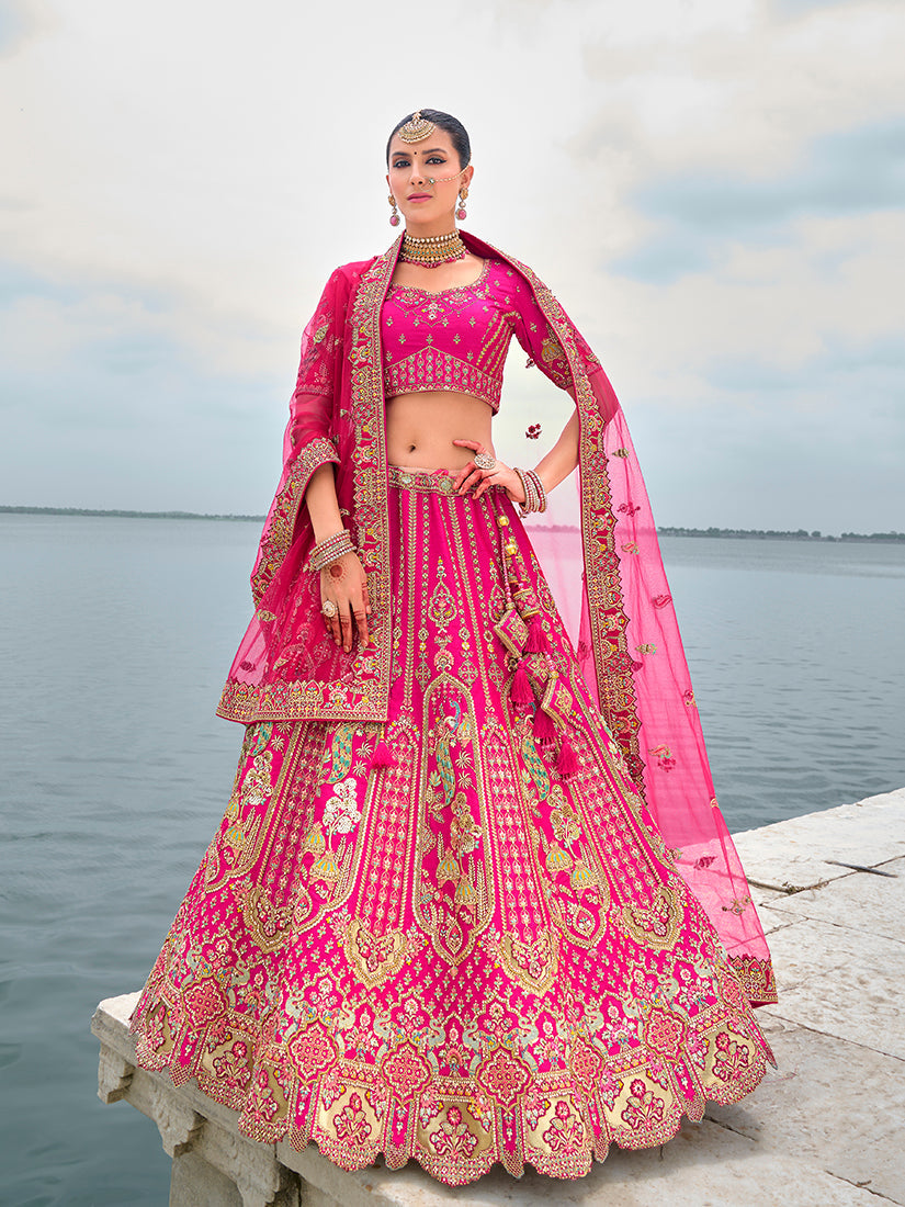 Luxury Rani Pink silk lehenga featuring detailed embroidery and Zari embellishments.