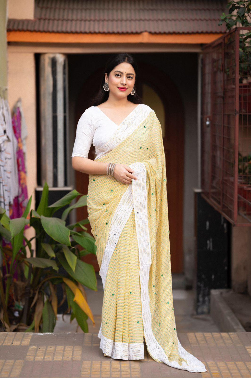 Lemon color poly georgette saree with allover prints and Aari mirror work border