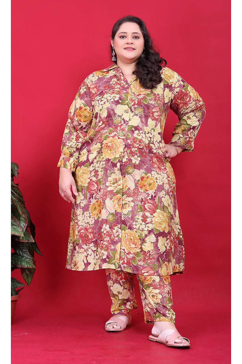A woman wearing a maroon-based multicolor floral print co-ord set with a collared button-down top.