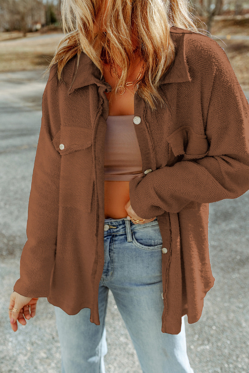 Woman wearing a chocolate brown oversized button-front knit shacket with reverse seam detailing