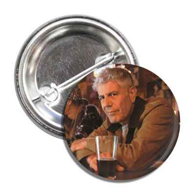 A 1-inch circular pinback button featuring a tribute design to Anthony Bourdain.
