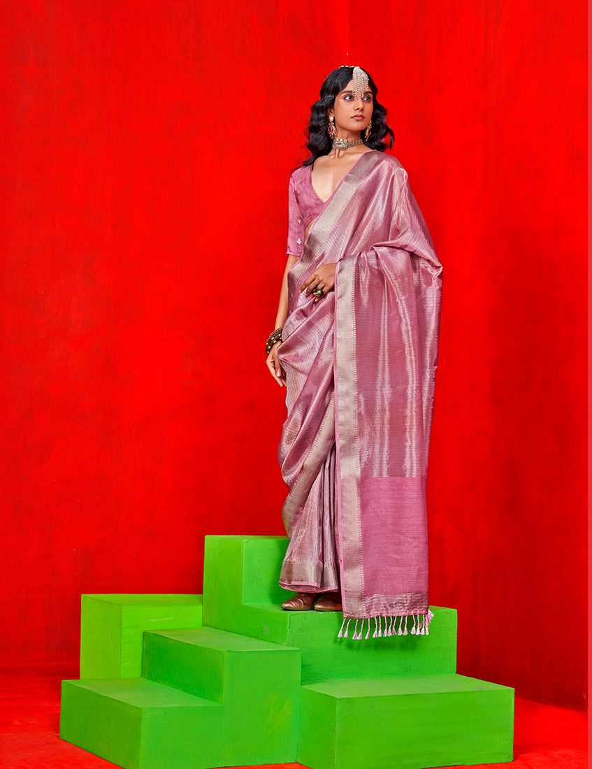 A light pink tissue saree with intricate gold zari weaving work.