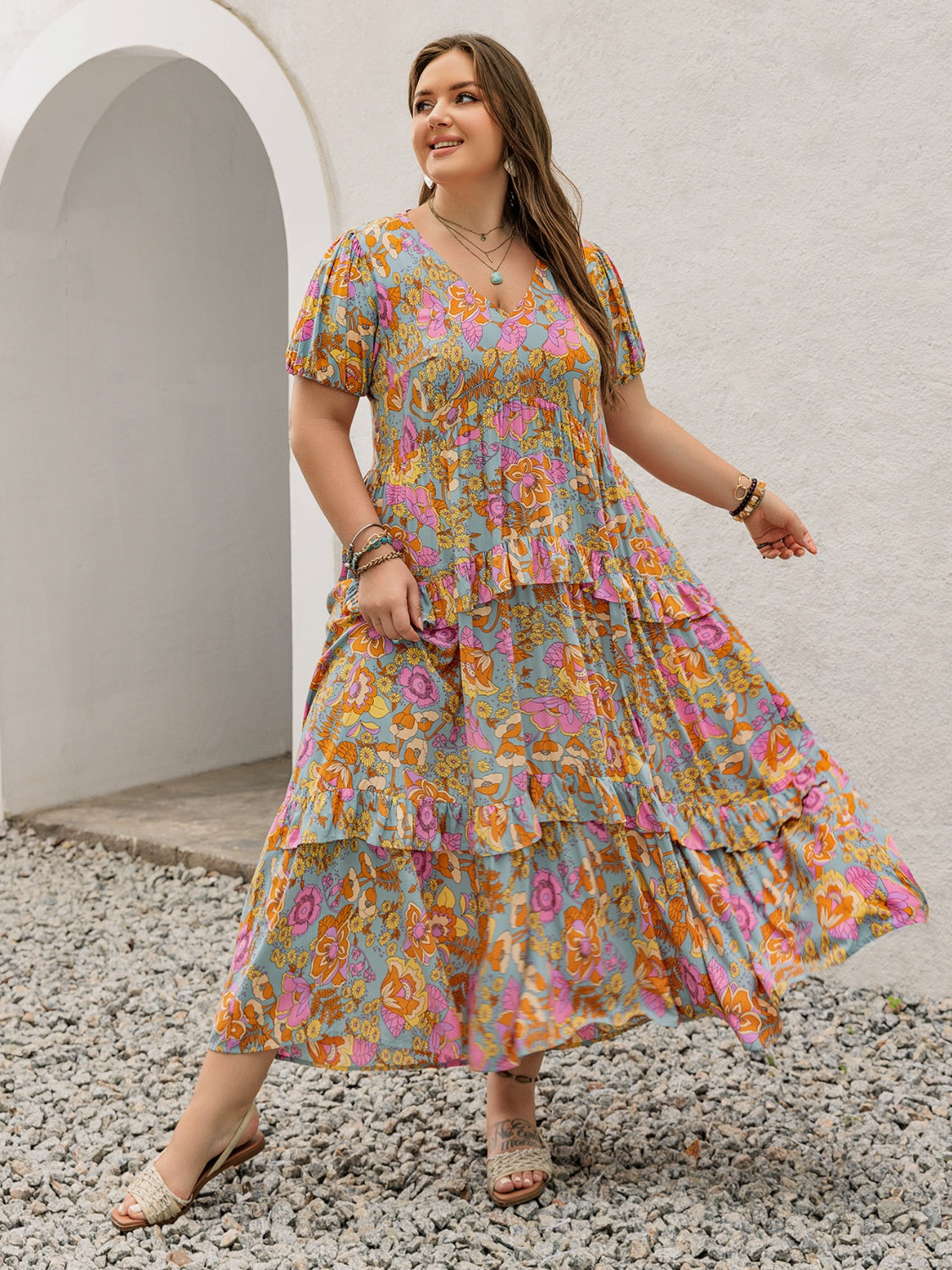 Model wearing a flowy floral printed maxi dress with V-neck and ruffled sleeves