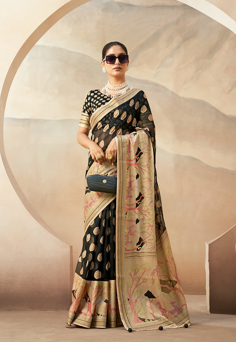 Model wearing a black georgette saree with intricate gold zari weaving patterns
