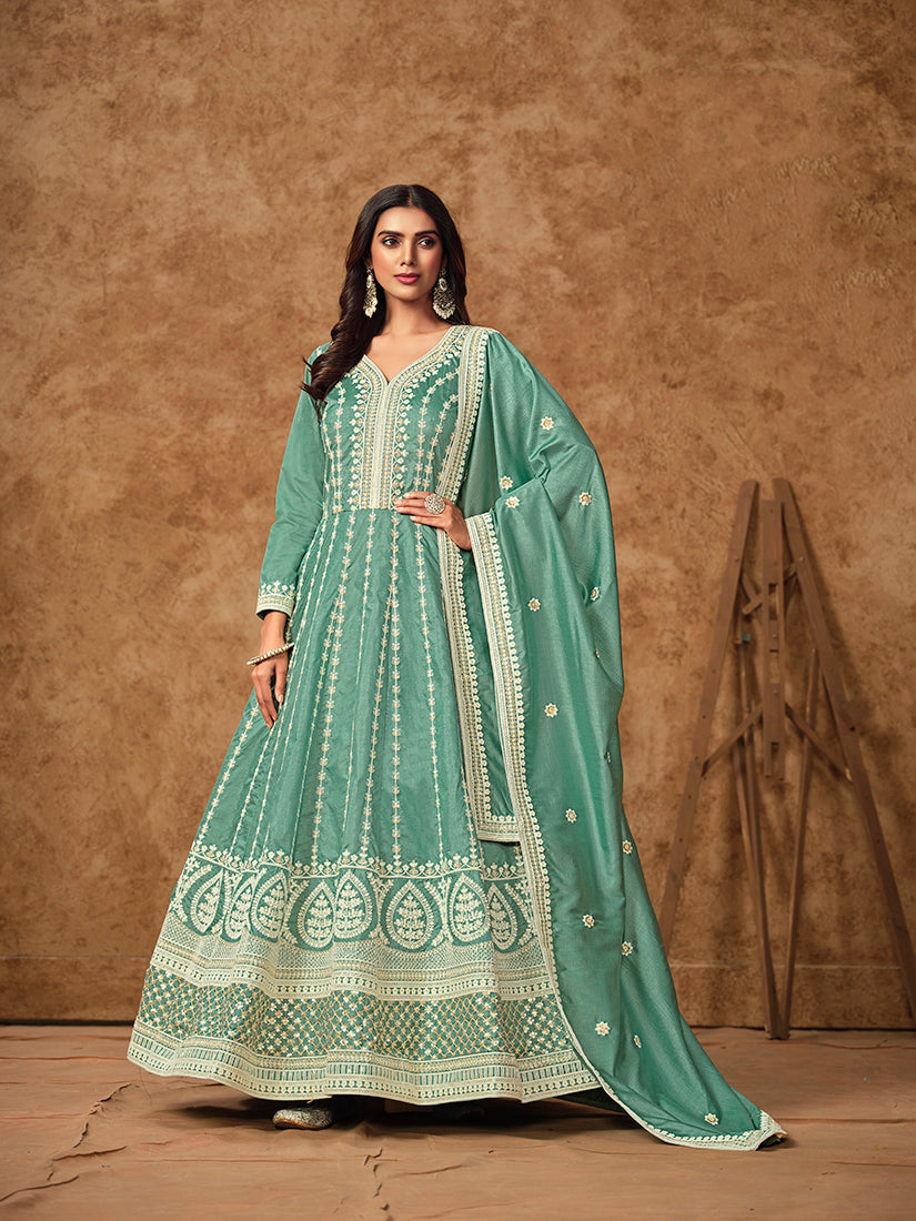 Woman wearing an elegant aqua-blue embroidered Dola silk salwar suit with intricate detailing