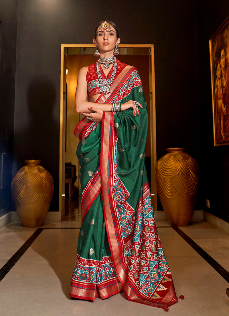 Dark green silk saree featuring traditional Patola print work