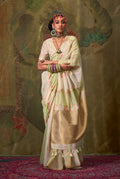 A sophisticated cream handloom cotton saree featuring subtle weaving details, paired with a matching blouse.