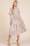 Feminine midi dress with floral embroidery, puff sleeves, and a tiered skirt.
