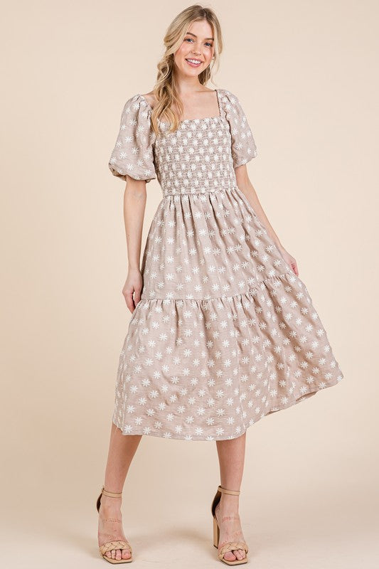 Feminine midi dress with floral embroidery, puff sleeves, and a tiered skirt.
