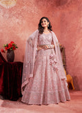 Pink net lehenga choli with intricate thread embroidery for festive occasions