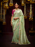 Sea green Kanjivaram silk saree with traditional beadwork and golden zari borders.