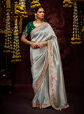 A beautiful grey Kanjivaram silk saree featuring detailed sequin work, zari embroidery, and a matching blouse.
