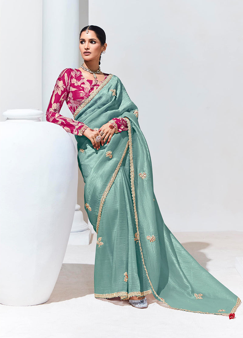 Model wearing an elegant aqua blue embroidered organza silk saree with detailed embroidery.