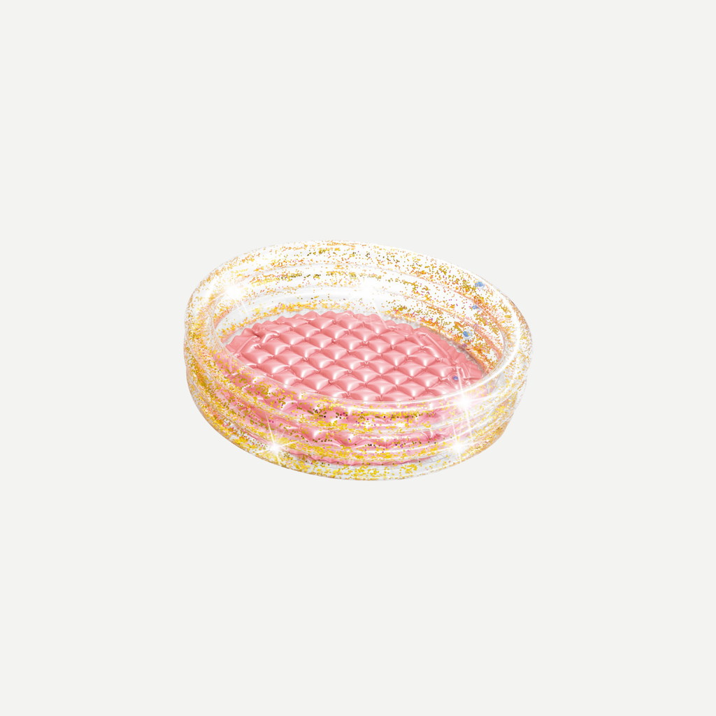 A toddler-sized inflatable pool with a glittering design sitting on grass