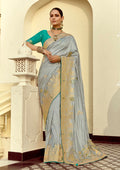 Light grey silk blend saree with intricate weaving and Swarovski crystals.