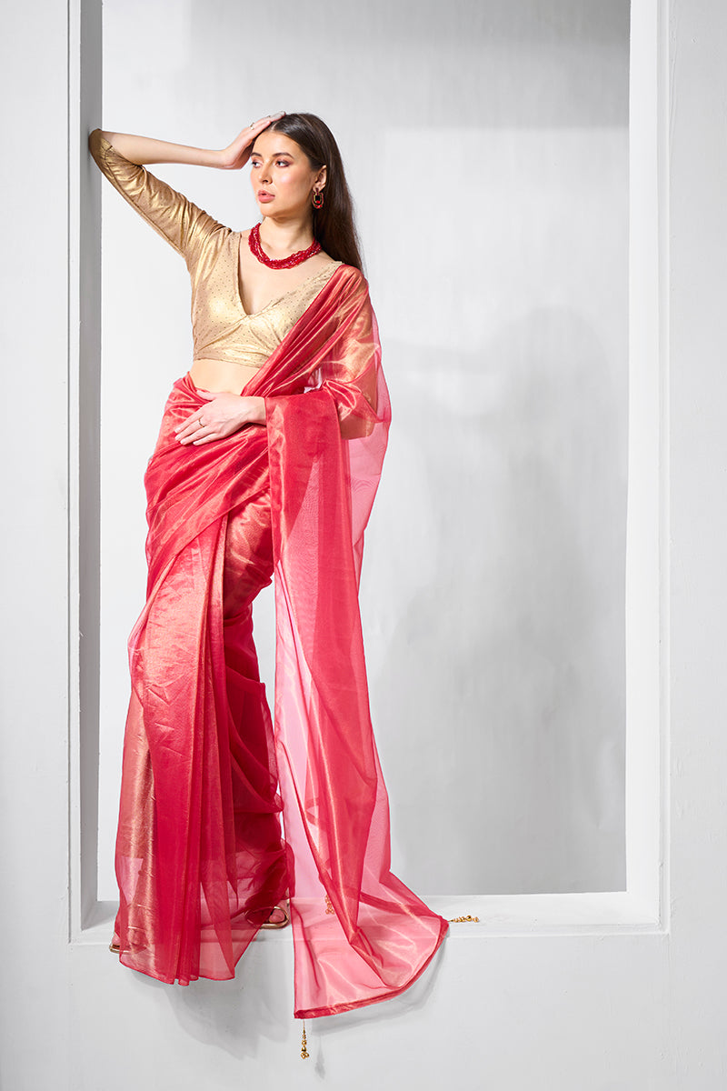 A beautiful red and gold tissue net saree displayed for party wear