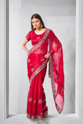 Rani pink chiffon saree with intricate gold embroidery and traditional drape