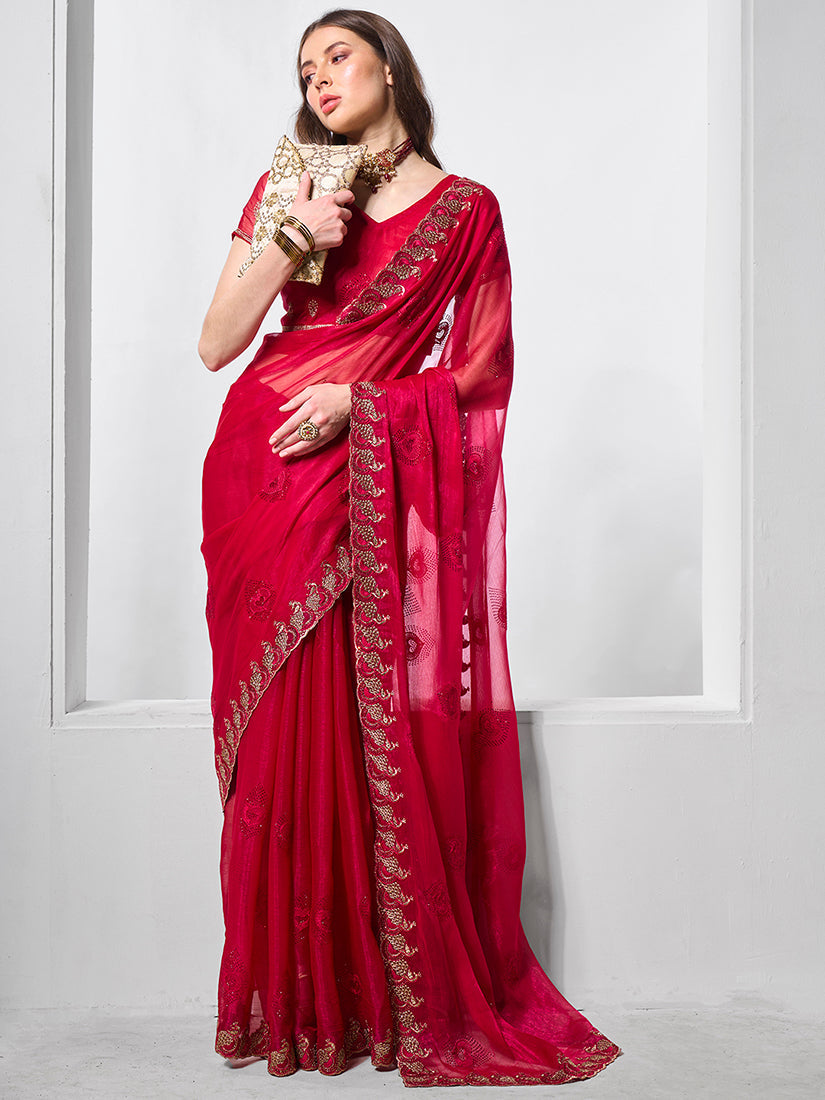 Woman wearing a vibrant rani pink shimmer chiffon saree with gold stone embroidery and matching V-neck blouse