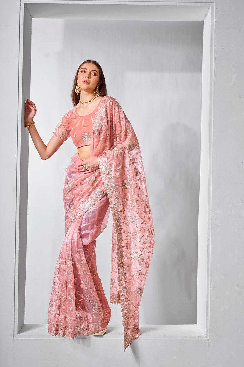 Peach colored tissue net saree featuring delicate gold embroidery.