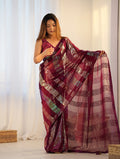 Woman wearing a maroon georgette classic saree with intricate sequin embroidery.